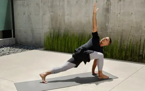 Man i yoga-ställning, med en arm sträckt uppåt. Han springer fort i sin träning.