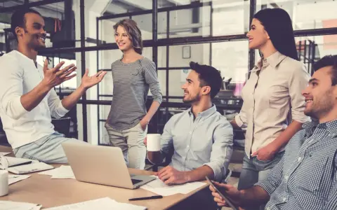 Un gruppo di persone in un ufficio moderno discute animatamente. I colleghi non sono amici, ma lavorano insieme con professionalità.