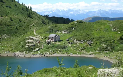 Sentiero per il lago di Erdemolo, con rifugio e montagne sullo sfondo.