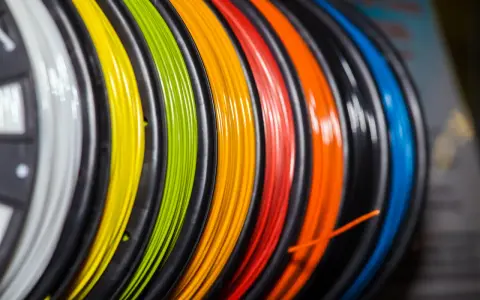 Kolorowy filament do druku 3D, nawinięty na szpulki. Zastanawiasz się, filament co to? To materiał do tworzenia trójwymiarowych obiektów.