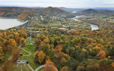 Jesienna panorama z widokiem na zaporę w Solinie i kolejkę gondolową. W oddali jezioro i góry.