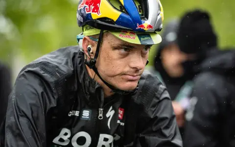 Anton Palzer im Regen, mit Red Bull Helm und BORA-Hansgrohe Jacke.