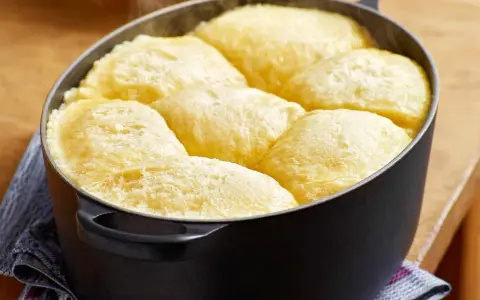 Frisch gebackene Dampfnudeln in einem schwarzen Topf. Ein köstliches Dampfnudel Rezept, das du unbedingt ausprobieren musst!