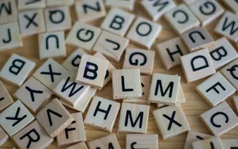 Drewniane klocki z literami, jak w grze Scrabble. Układają się w słowa, może nawet w najdłuższe słowo po angielsku?