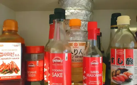 Szafka z azjatyckimi sosami. Widać sosy: Capsaicin sauce, Cooking Sake, Mirin seasoning. Zastanawiasz się, mirin czym zastąpić?