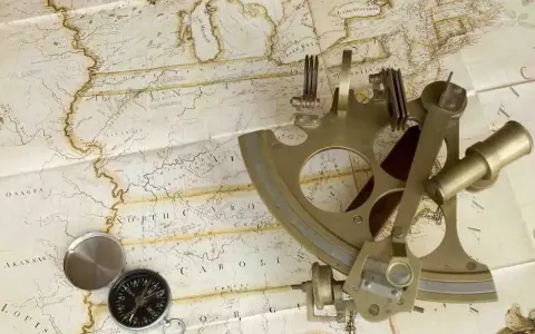 Un sextant et une boussole sur une carte ancienne, évoquant la navigation et l'exploration.