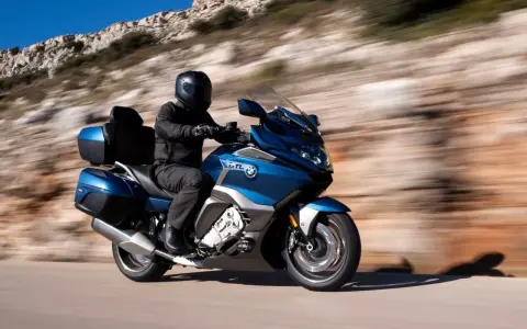 Motocyklista w kasku przemierza malowniczą trasę, odkrywając różne rodzaje turystyki.