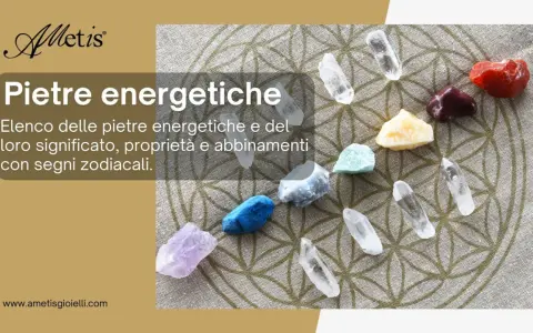 Pietre colorate disposte su un tessuto con il simbolo del Fiore della Vita. Il testo parla del significato delle gemme.