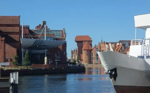 Gdańsk Starówka atrakcje: biały statek na pierwszym planie, w tle zabytkowe kamienice i Żuraw.