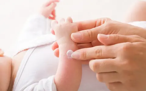 Application de cicalfate nourrisson sur le bras d'un bébé par une main douce.