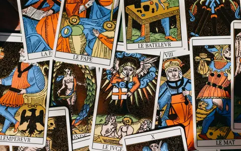 Rozłożone karty tarota, w tym "Le Pape" i "Le Bateleur". Wśród nich widać postacie aniołów i ludzi, jakby kapłan tarot odsłaniał tajemnice przyszłości.