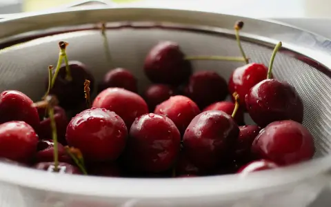 Frisch gewaschene Kirschen in einem Sieb, bereit für das Einkochen ohne Zucker.