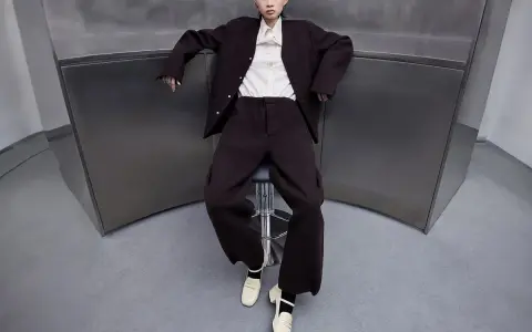 A woman in a dark suit and cream blouse wears cream loafers, showcasing what shoes are considered business casual for a woman.