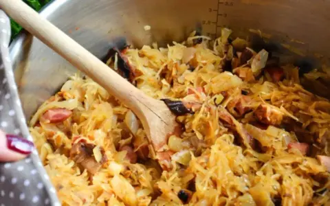 Gotujesz bigos? W garnku widać kapustę kiszoną z różnymi rodzajami mięsa, jak wieprzowina i kiełbasa. Idealne jakie mięso do bigosu!