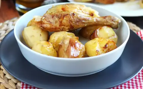 Un invitante pollo al forno con patate dorate, un classico piatto che profuma di casa.