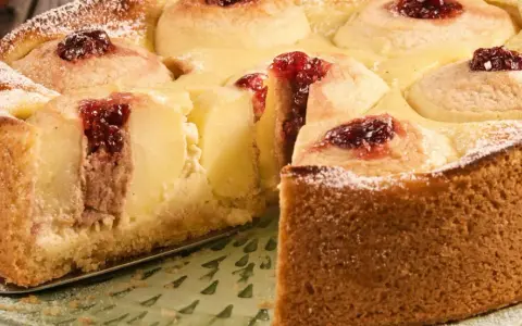 Saftiger Bratapfelkuchen mit Marzipan, verziert mit Marmelade und Puderzucker. Ein Genuss für jeden Anlass.