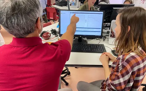 Un homme montre un audiogramme sur un écran, peut-être lors d'une formation pour obtenir son diplôme d'audioprothésiste en Espagne.