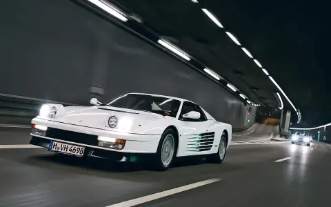Weißer Ferrari Testarossa fährt durch einen beleuchteten Tunnel.