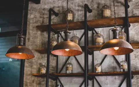 Industrialne lampy wiszące nad półkami ze słoikami. Dowiedz się, jak wyczyścić abażur z lampy, by odzyskał dawny blask.
