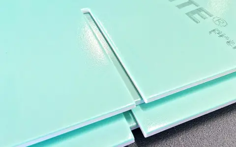 Mehrere hellgrüne Hartschaumplatten liegen übereinander. Eine Platte zeigt eine gerade Schnittkante, die das Schneiden von Hartschaumplatten verdeutlicht.