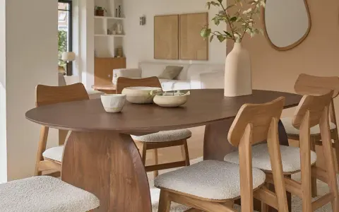 Table et chaises en bois mindi dans une salle à manger lumineuse. Des bols décoratifs et une plante apportent une touche naturelle.