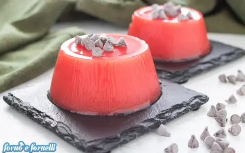 Delizioso gelo di melone, un dolce fresco e colorato, guarnito con gocce di cioccolato.