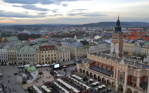 Widok na Rynek Główny w Krakowie z dominującą wieżą mariacką. Widać Sukiennice, kościół św. Wojciecha i stragany jarmarku.