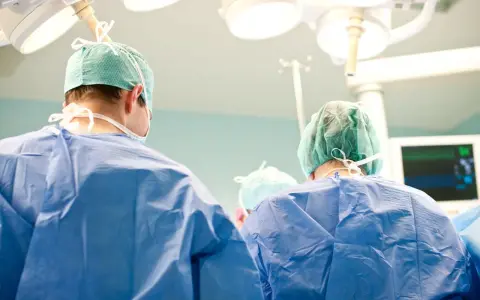Chirurdzy w zielonych czepkach i niebieskich fartuchach przygotowują się do klasycznej operacji prostaty.