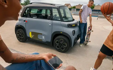 Jóvenes con patineta y balón de baloncesto cerca de un coche gris. ¡Qué ganas de tener el permiso AM que puedo conducir!