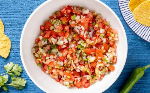 Pico de gallo ricetta: pomodori, cipolla, peperoncino e coriandolo freschi, pronti per essere gustati con nachos.