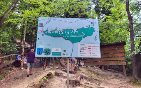 Mapa szlaku w rezerwacie przyrody "Prządki" im. prof. Henryka Świdzińskiego. Turyści z psem zwiedzają malowniczą okolicę.