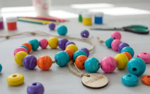 Färgglada träpärlor och pysselmaterial ligger utspridda, redo för att måla med barn. En härlig aktivitet för kreativa stunder.
