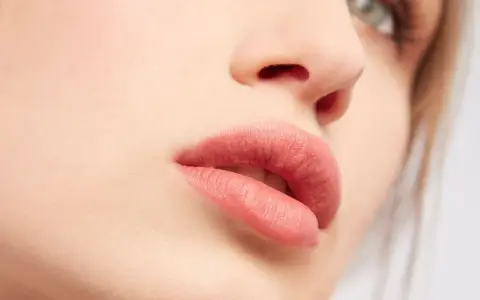 Labbra sensuali con rossetto color carne, un look naturale che esalta la bellezza di ogni donna.