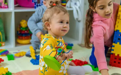 Niños jugando con bloques y juguetes, fomentando el desarrollo del niño de 0 a 6 años.