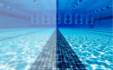 Underwater view of a swimming pool, half clear and half cloudy, with lane lines and lane markers.
