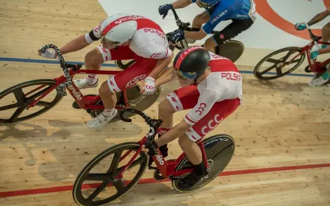 Wyścig kolarski madison. Dwóch kolarzy w biało-czerwonych strojach jedzie na torze.