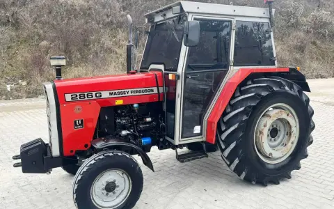 Czerwony Massey Ferguson 286G z kabiną, gotowy do pracy. Jego solidna konstrukcja i moc zapewniają niezawodność.