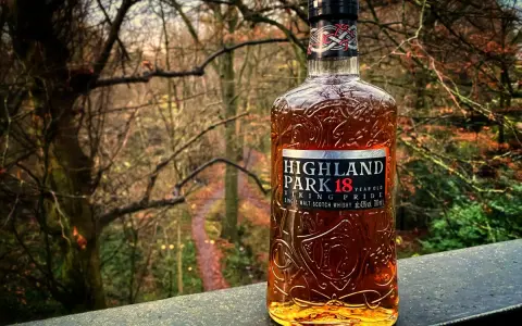 Butelka whisky Highland Park 18 Year Old na tle jesiennego lasu.
