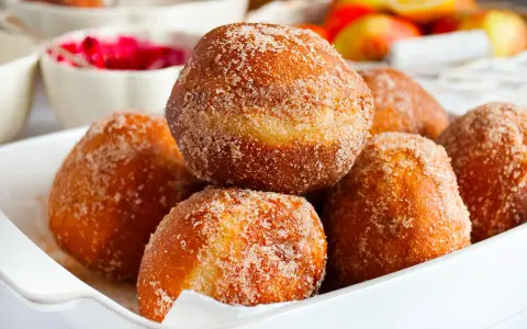 Puszyste pączki posypane cukrem z cynamonem, idealne na tłusty czwartek. Ten przepis na puszyste pączki to gwarancja sukcesu.