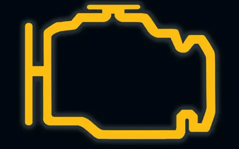 Żółty symbol silnika na ciemnym tle. Migający check engine to znak, że coś jest nie tak z samochodem.