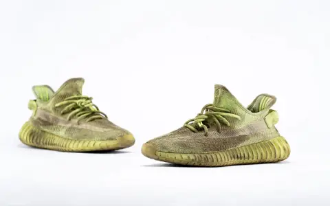 Para zielonych adidas Yeezy 350 z charakterystyczną, prążkowaną podeszwą, gotowe na miejskie przygody.