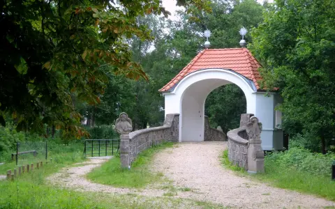 Kamienna furtka z aniołami prowadzi do Kalwarii Wielewskiej. Kręta ścieżka wśród zieleni zaprasza do kontemplacji.