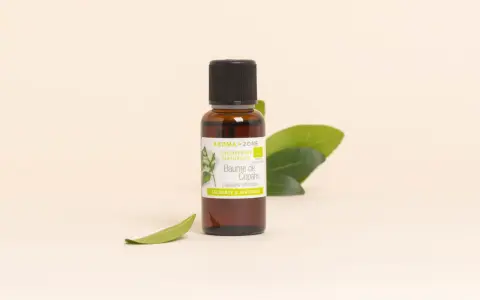 Flacon de baume de copahu, une oléorésine naturelle aux vertus calmantes et apaisantes, entouré de feuilles vertes.