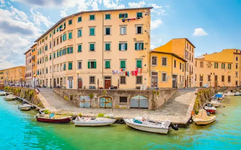 Canali di Livorno, un'idea per cosa vedere a Livorno in un giorno. Case colorate e barche sull'acqua turchese.