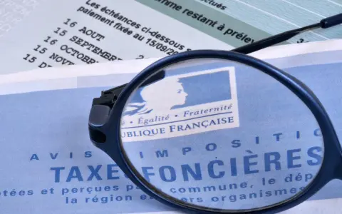 Loupe sur un avis de taxe foncière par commune. Le document mentionne "République Française" et des dates d'échéances.