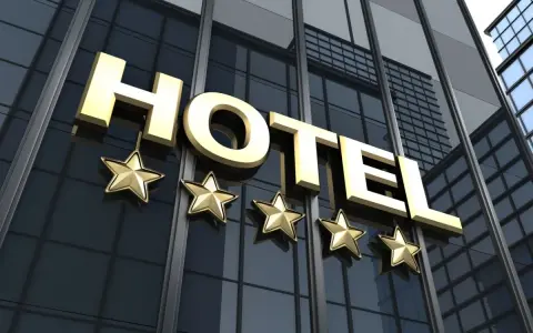 Złoty napis HOTEL i pięć gwiazdek na nowoczesnym budynku. Marzysz, jak zostać testerem hoteli w Polsce?
