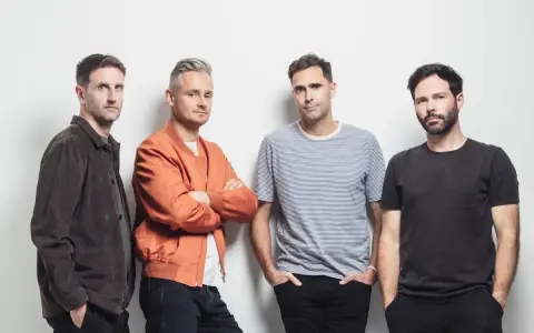 Le groupe Keane pose pour une photo, quatre hommes regardant la caméra.