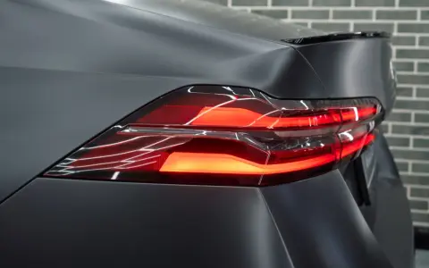 Przyciemnianie lamp tylnych w matowym, ciemnym samochodzie. Nowoczesne światła LED tworzą efektowny wzór.