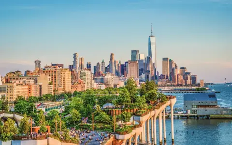En grönskande park på pelare med New Yorks skyline i bakgrunden. Perfekt för tips på nya upplevelser i New York.