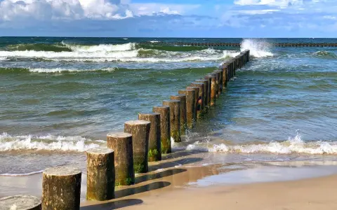Jastrzębia Góra co zobaczyć: falochrony na plaży i wzburzone morze. Idealne miejsce na spacer i podziwianie Bałtyku.